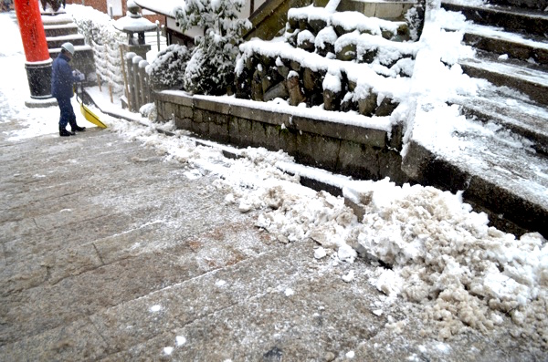 階段に積もる雪を端へ