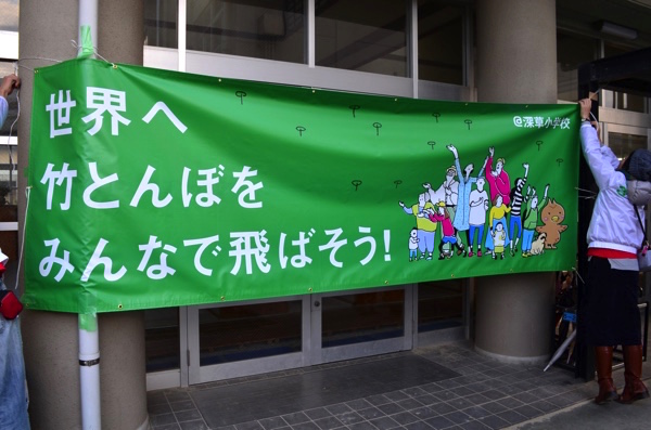 「世界へ竹とんぼをみんなで飛ばそう! 」と書かれた横断幕